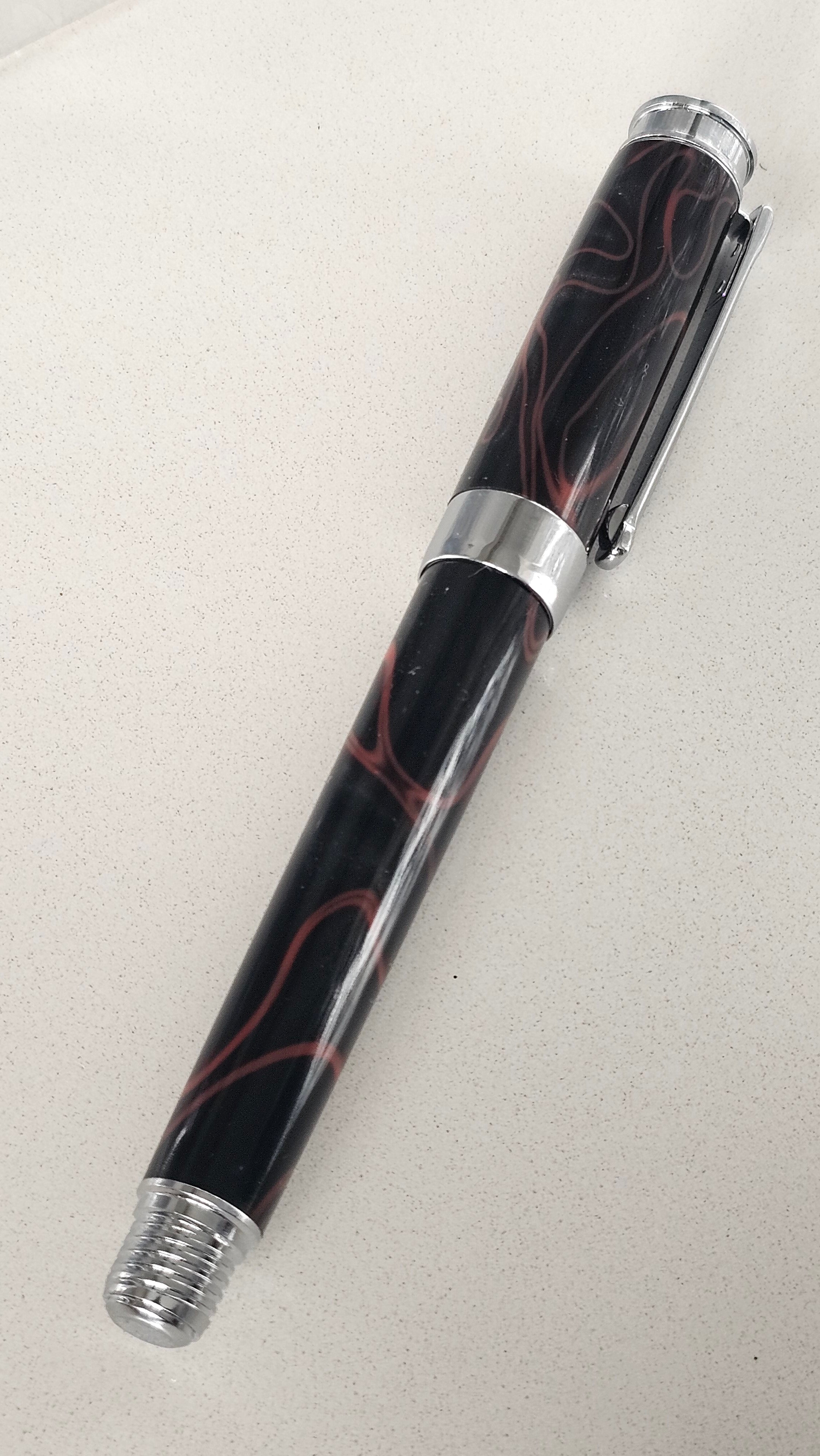 The Cosmic Fire Fountain Pen.  Forged from "Supernova" resin with a gold-plated nib, this unique celestial tool turns every word into a work of art.
